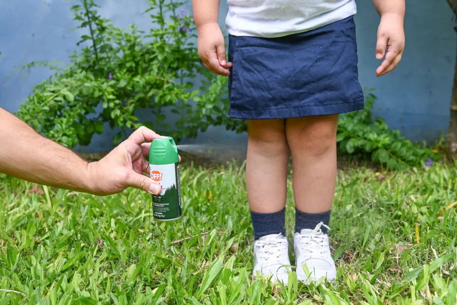 Campaña dengue - adulto colocandole repelente a une niñe