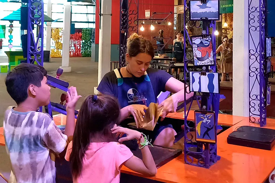 Niños jugando con sellos y tintas en el kiosquito de las formas y figuras en La Isla de los Inventos