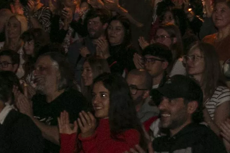 Es una imagen de una parte del público presente en una obra de teatro 