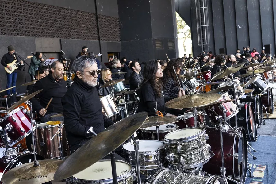Es la imagen de un grupo de personas tocando baterías