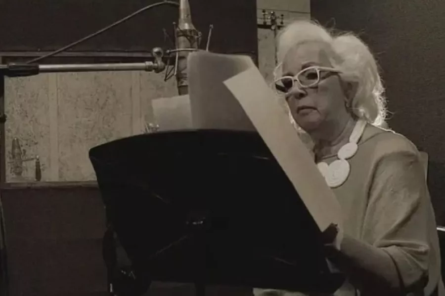 Es la imagen de una mujer que está leyendo una partitura de música 