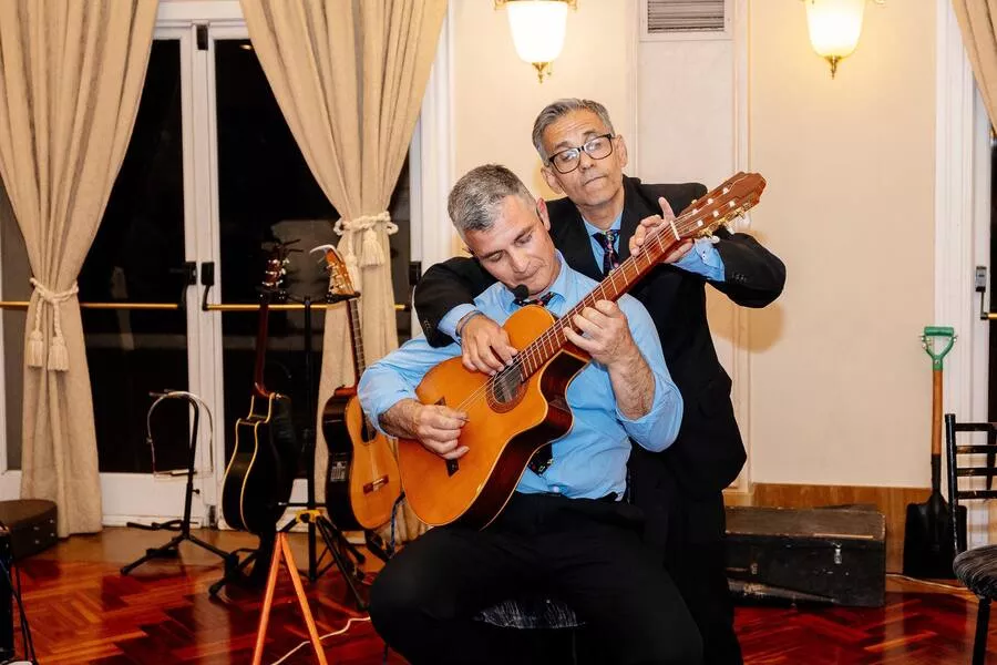 Es la imagen de dos músicos tocando la guitarra