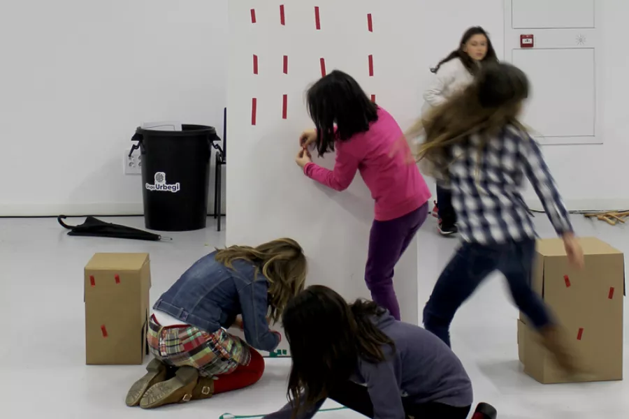 niños participando de un taller con cajas sobre  y cintas