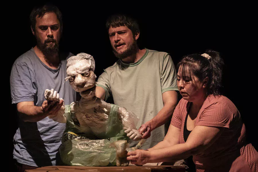 Es la imagen de un grupo de personas tocando una escultura