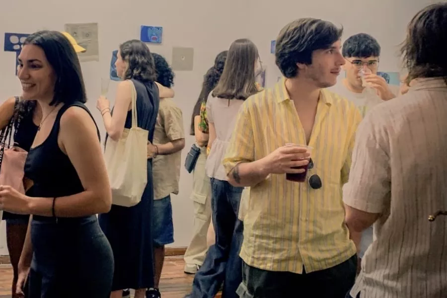 Es la imagen de un grupo de personas observando obras de arte