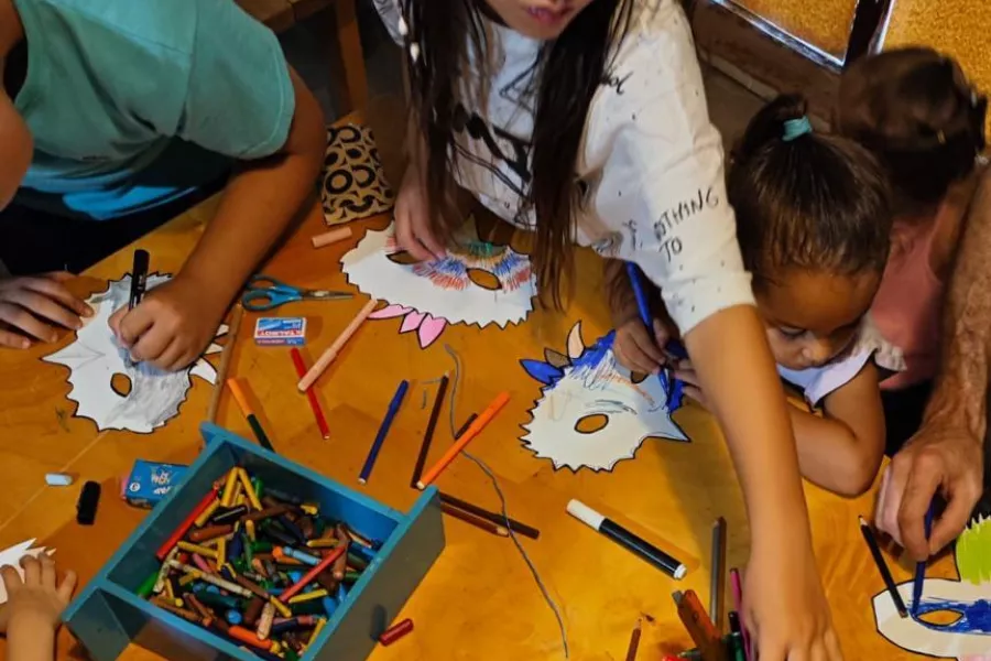 Es la imagen de infancias pintando sobre una mesa