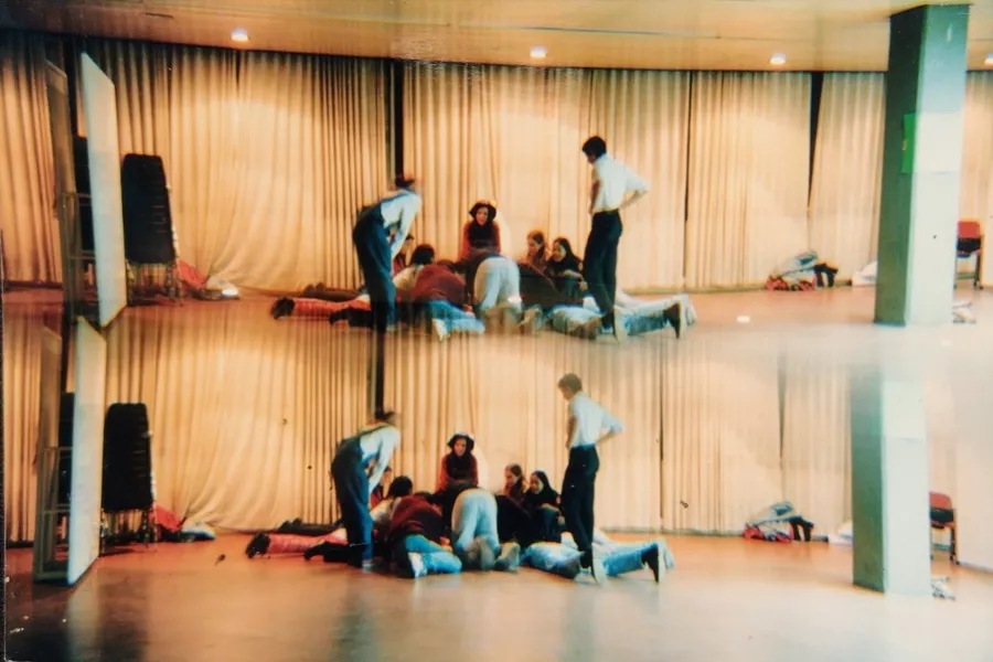 Es la imagen de un grupo de personas haciendo ejercicios de teatro