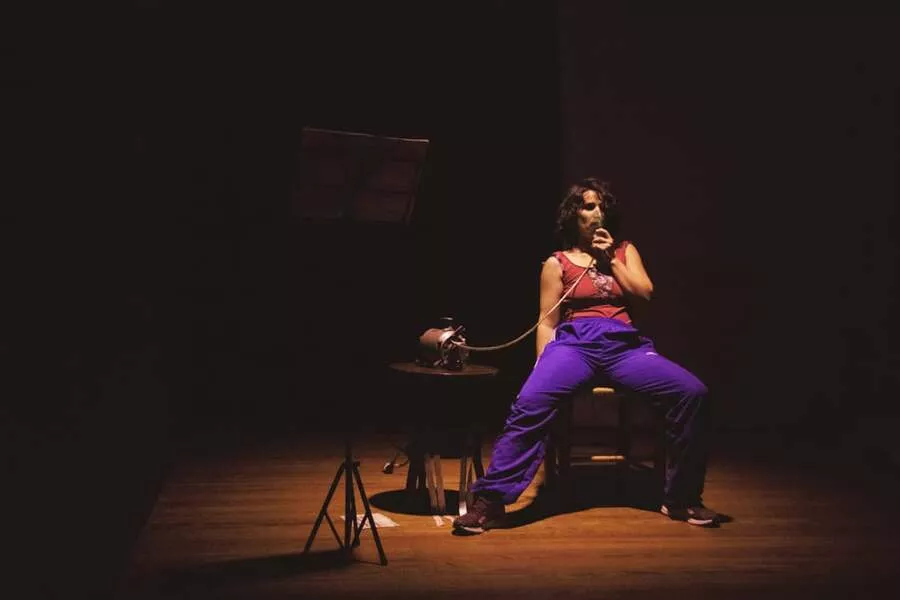 Es una imagen de una bailarina que está sentada en una silla con un respirador