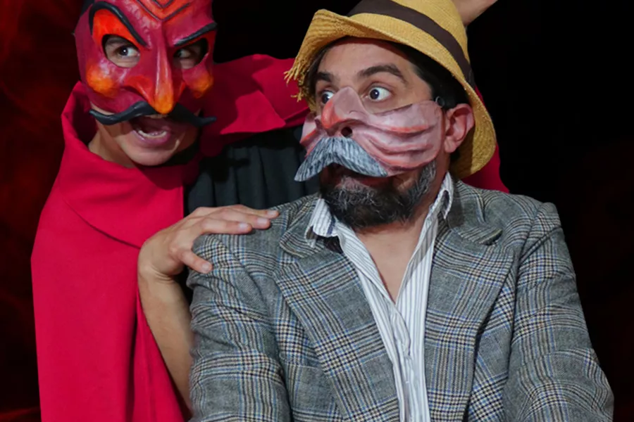 Es la imagen de dos actores caracterizados como sus personajes: uno con un disfraz del diablo y el otro actor con un sombrero y una máscara de animal