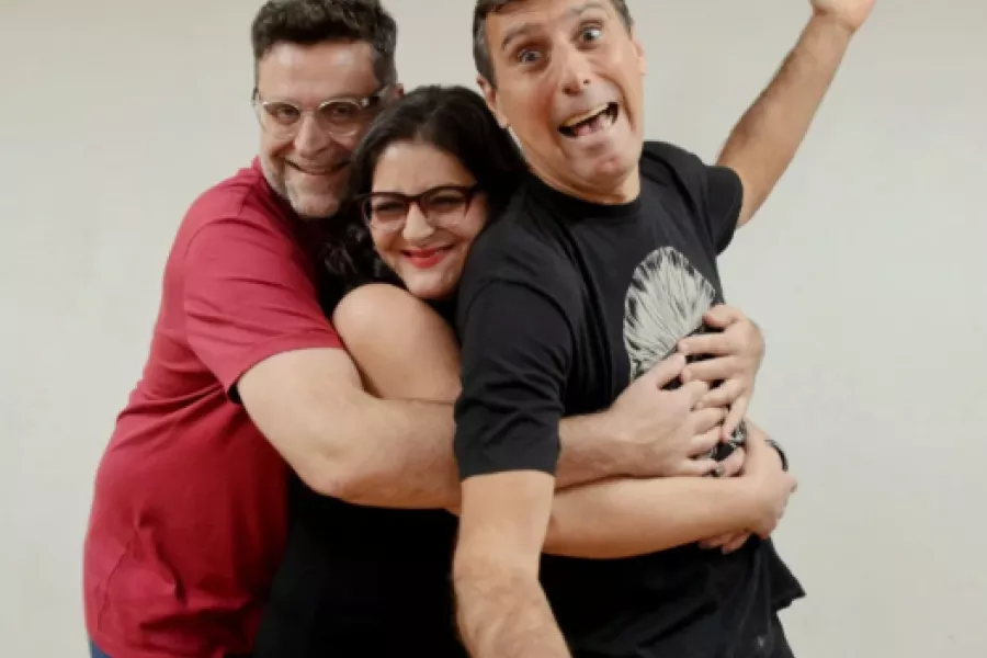 Es la imagen de tres comediantes posando sonriendo para una foto 