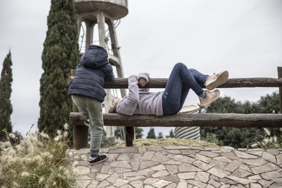 Dos niños trepados haciendo piruetas en el puente en La Granja de la Infancia