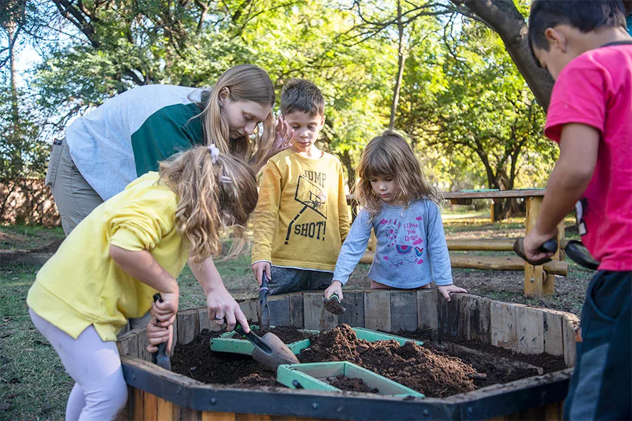 Niño alrededor del lombricario, explorando la tierra para encontar lombrices 