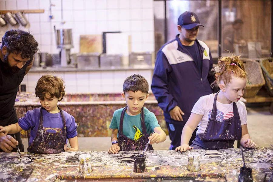Niños pintando con témperas y pinceles formas de cartón