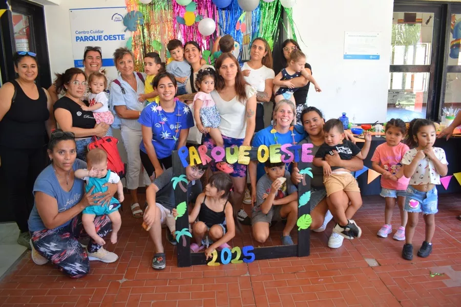 Es la imagen de un grupo de personas e infancias posando para una foto