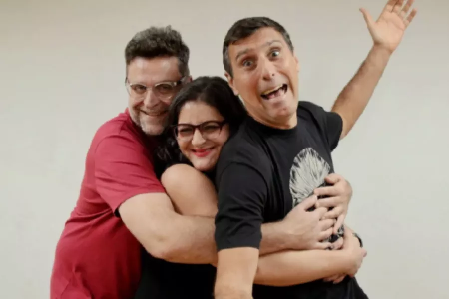Es la imagen de tres comediantes posando para una foto. Están sonriendo y haciendo caras