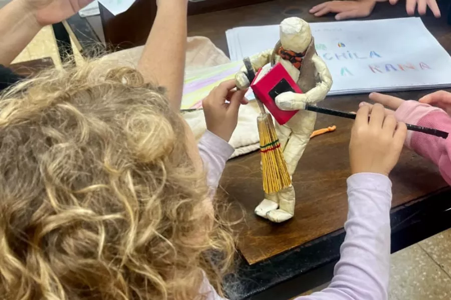 Niña jugando con un muñeco de madera