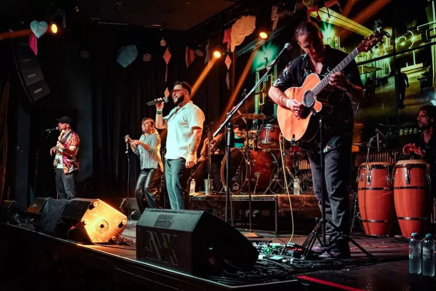 Es la imagen de un grupo musical tocando en un escenario