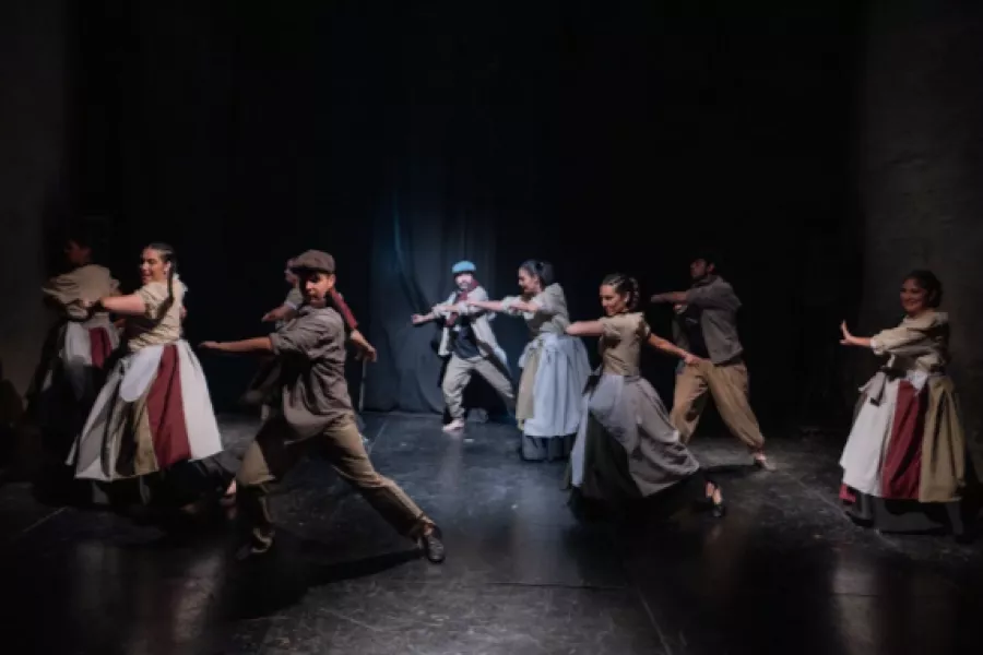 Es la imagen de un grupo de bailarines y bailarinas haciendo una coreo de folklore