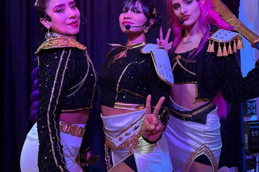 Es la imagen de tres cantantes posando para una fotografía