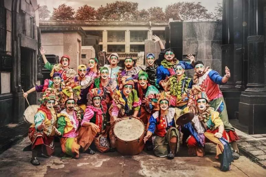 Es la imagen de una murga rosarina. Están vestidos con atuendos llenos de colores y maquillados
