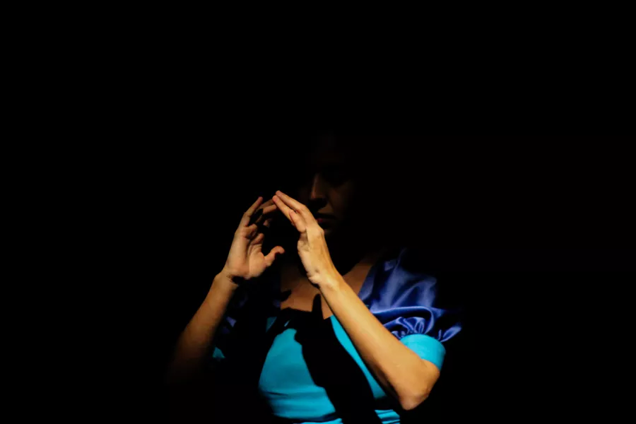 Es la imagen de una bailarina con un vestido azul en un fondo negro