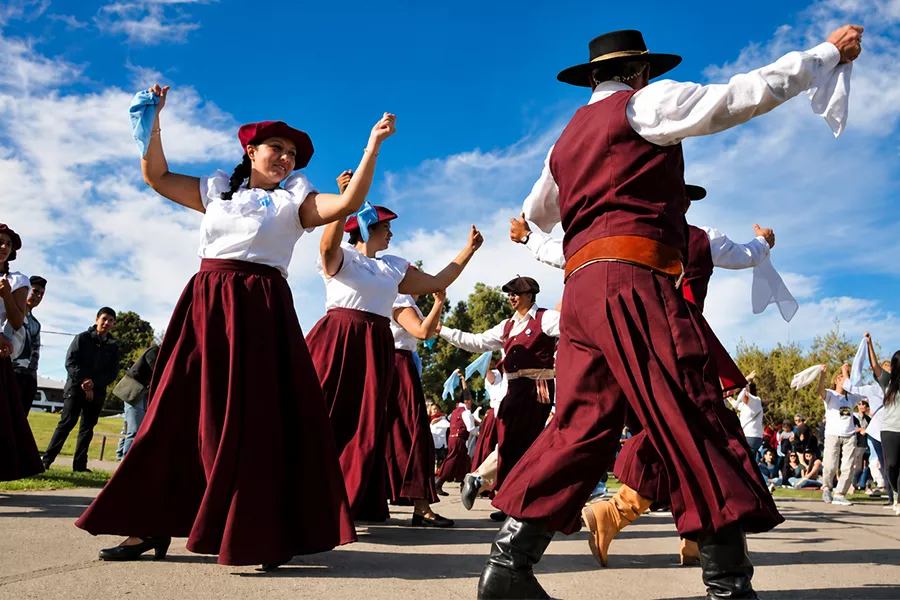 Gente bailando una chacarera en una peña folclórica
