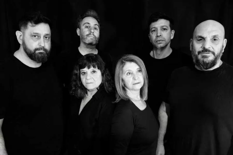 Es la imagen de un grupo de actrices y actores que forman parte del elenco de una obra de teatro. Están vestidos de negro