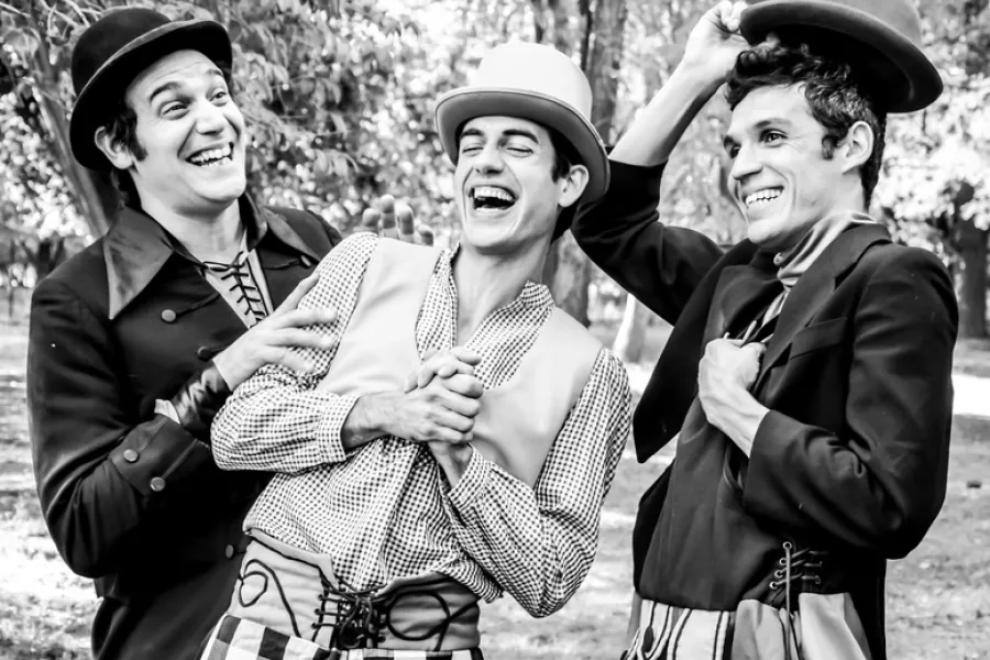 Es la imagen de tres actores caracterizados como sus personajes: con traje y sombreros