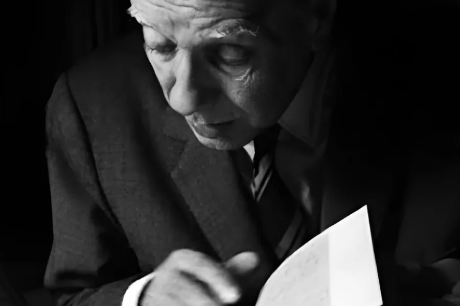 Imagen de Jorge Luis Borges ojeando un libro.