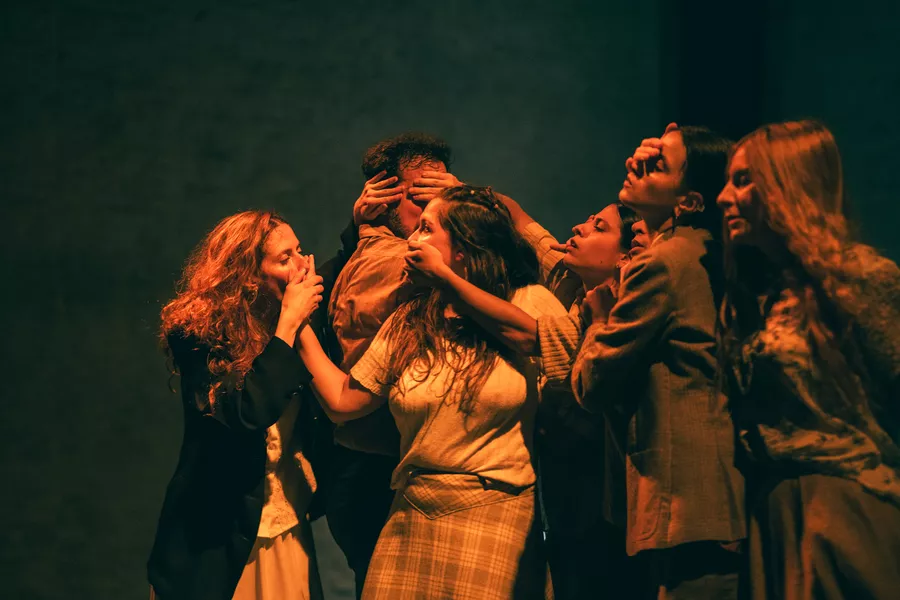 Es la imagen de un grupo de actrices que están haciendo una escena. Están juntas tapándose las bocas