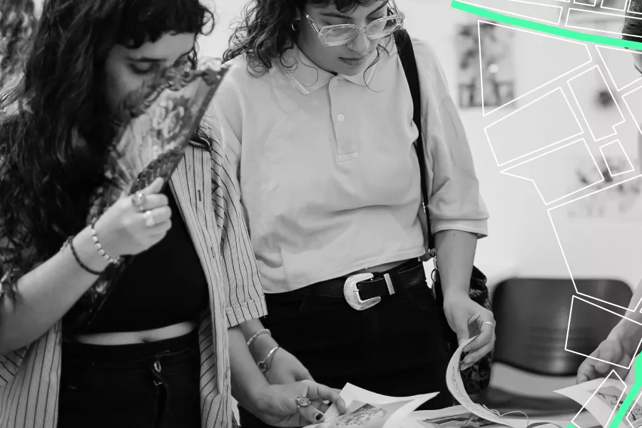 Dos chicas ojeando libros. Y las líneas del mapa de una ciudad a la derecha.