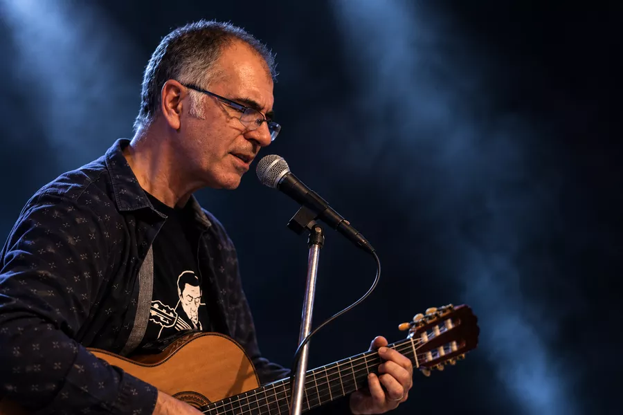 Es la imagen de un músico tocando una guitarra 