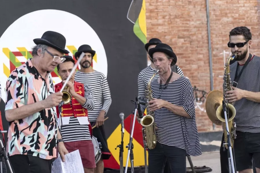 Es la imagen de un grupo de músicos tocando instrumentos de vientos. Están vestidos como mimos
