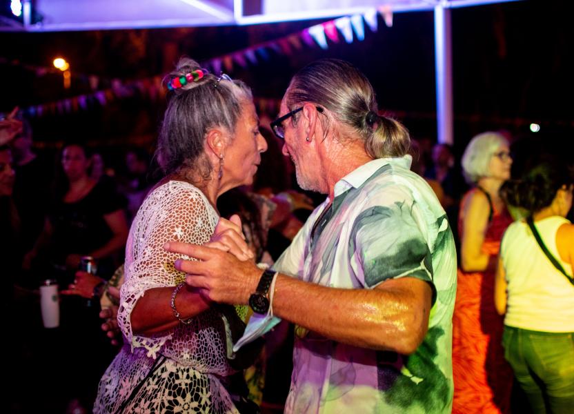 Imagen de una pareja de adultos mayores bailando juntos en la noche de carnaval. 